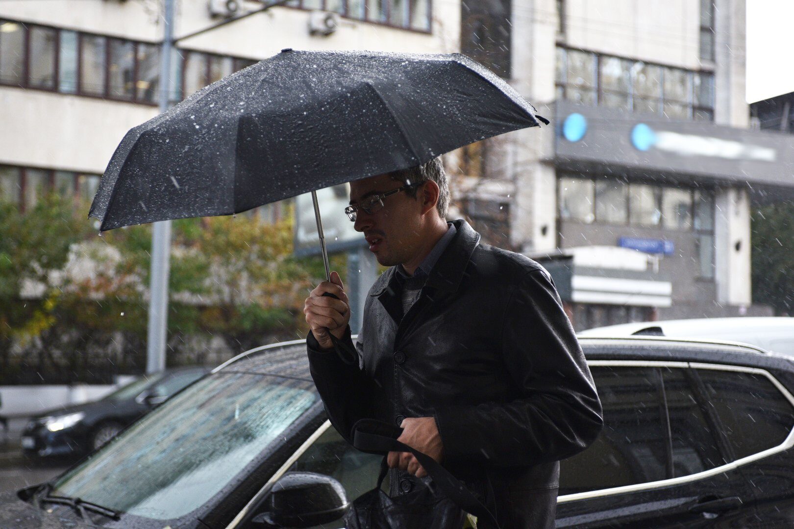 Забытый зонтик. Похолодание в Москве. Аварийный зонт метеорологов. Опасная погода. Фото мужчин на улице в пасмурную погоду.